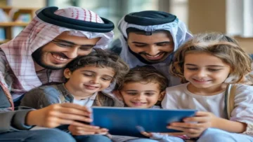 Happy Arab family with young children watching educational content on a tablet joyful and